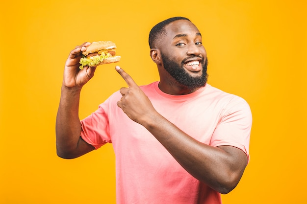 young-african-american-man-eating-hamburger-isolated-yellow-wall_255757-751-806731169.jpg
